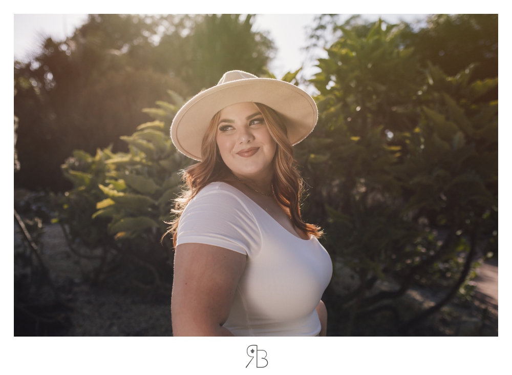girl back lit in nature cream top jeans tan hat Renee Bowen Senior Photographer