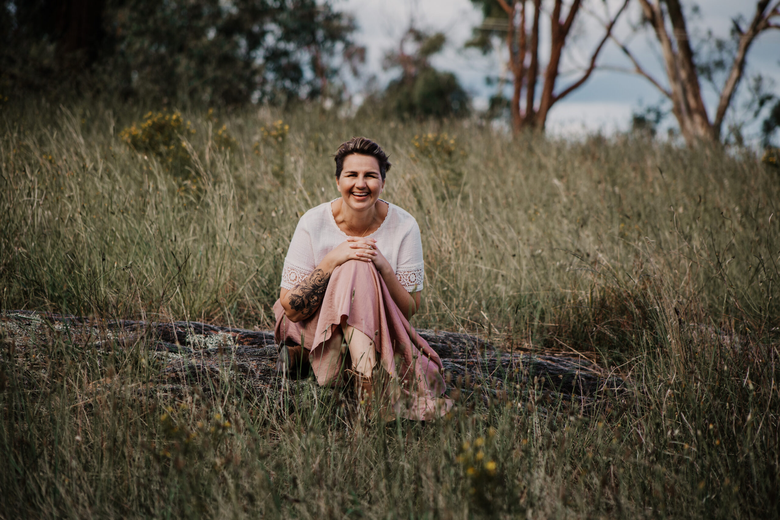 woman laughing sitting a field of grass